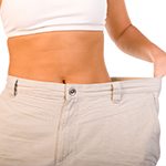 A person showing off their weight loss by pulling a large pair of pants away from their much smaller waist.