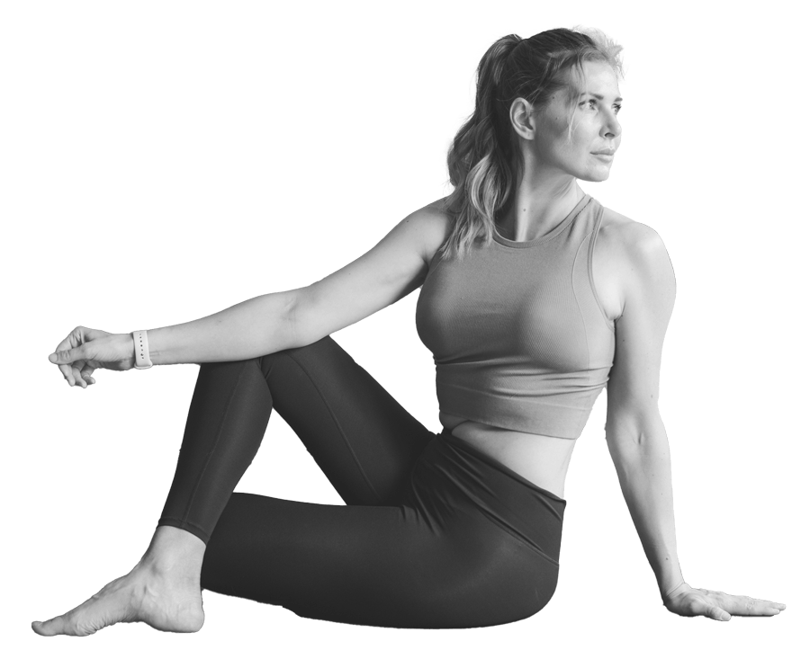 A woman is performing a seated yoga twist posture, wearing sportswear.
